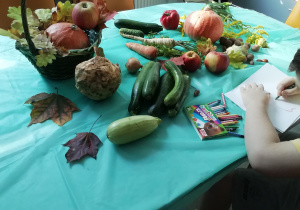 Wychowankowie rysują zaprezentowane warzywa i owoce.