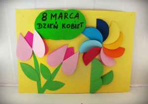 Różnokolorowe kwiaty wykonane z kół z papieru, przyklejone do kartonu.