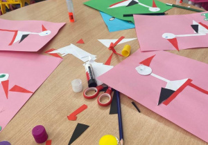 Wykonywanie przez dzieci prac plastycznych, na których znajdują się bociny, wykonane z trójkątów, kółek i prostokątów.