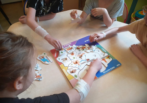 Dzieci układające puzzle patriotyczne.