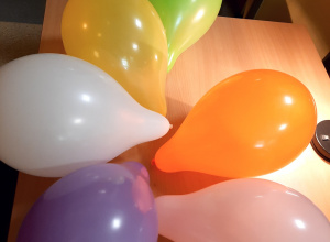 Różnokolorowe balony leżące na stole.