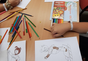 Dzieci kolorują obrazki przedstawiające bohaterów bajek.