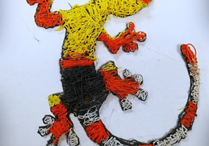 Kolorowa jaszczurka w kolorach żółtym, czarnym, czerwonym i białym, wykonana długopisem 3D.