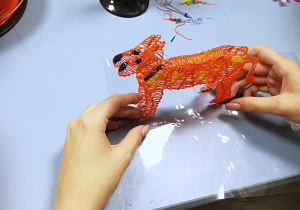 Pomarańczowy przestrzenny pies, wykonany długopisem 3D.