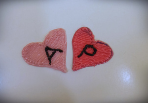Na zdjęciu dwa serca wykonane długopisem 3 d. Serca są w różowym kolorze i maja litery A i P.