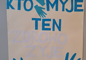 plakat z niebieskim napisem "Kto ręce myje ten zdrowo żyje"