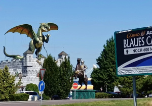 Zdjęcie na którym widać smoka na postumencie, rycerza w zbroi na koniu i makieta zamku.