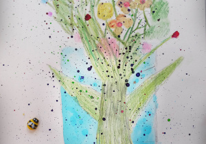 Praca plastyczna przedstawiająca kwitnące drzewo. Wokół przyklejone są drewniane biedronki i pszczółki.