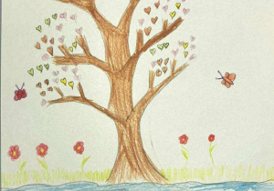Brązowe drzewo narysowane kredkami ołówkowymi na środku kartonu. Na gałęziach zamiast liści są różnokolorowe, pastelowe serduszka. Nad drzewem znajdują się błękitne chmurki, a pod nim zielona trawa i kwiaty. Pracę namalowała Zuzia.
