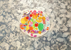 Obraz przedstawia kompozycję w stylu dekoracyjnym, z wyraźnym kontrastem pomiędzy tłem a centralnym elementem: Opis szczegółowy: Tło: Dominują odcienie szarości i bieli, tworzące wzór z motywem liści. Liście są rozmieszczone gęsto, w różnych kierunkach, co nadaje tłu fakturę przypominającą tapetę lub odbitkę roślinną. Centralny element: W środku znajduje się okrągła forma przypominająca talerz lub abstrakcyjną kompozycję. Wewnątrz okręgu widoczne są intensywne, żywe kolory: czerwienie, pomarańcze, żółcie, fiolety, zielenie. Kształty są nieregularne, przypominają owoce, kwiaty lub plamy barwne – np. czerwone kuliste formy jak jabłka, zielony owal jak arbuz, pomarańczowe i żółte plamy jak cytrusy. Całość wygląda jak kolorowa, abstrakcyjna martwa natura lub fantazyjna interpretacja miski pełnej owoców i kwiatów.