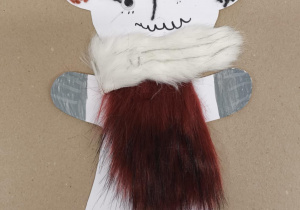 Papierowy miś ozdobiony jasnym futerkiem na szyi i ciemnym na brzuszku, z kolorowymi detalami na głowie.