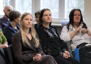 Na zdjęciu widać grupę dorosłych siedzących blisko siebie w sali konferencyjnej. Na pierwszym planie - centralnie nasza Pani Dyrektor Sylwia Kowalczyk.