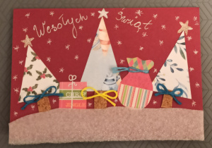 Bordowa kartka, na której znajdują się trzy choinki pomiędzy którymi znajdują się prezenty świąteczne