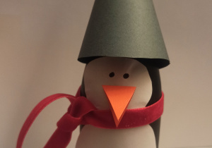 Pingwin wykonany z papieru z trójkątną czapką na głowie