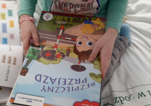 Dziecko trzymające książkę Bezpieczny przejazd