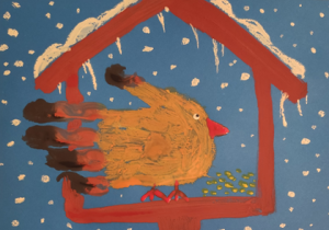 Ptak siedzący w karmniku zimą