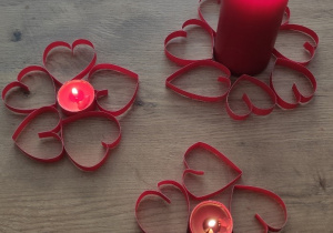 Walentynkowe świeczniki umieszczone między sercami wyciętymi z kolorowego papieru