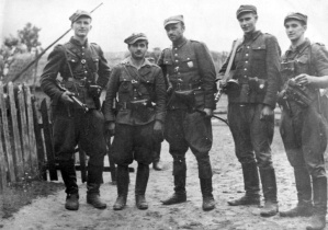 Żołnierze z V Wileńskiej Brygady Armii Krajowej w szarych mundurach i z bronią w ręku