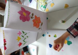 Dzieci tworzą kolorowe laurki z kwiatami