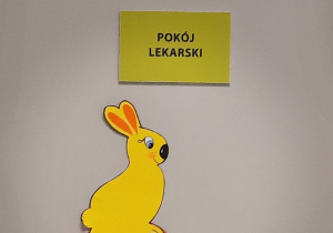 Królik siedzący na pisance w grodszki przyklejony do drzwi.