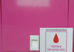 Na zdjęciu różowa, metalowa skrzyneczka z napisem www.rozowaskrzyneczka.pl i Tu znajdziesz darmowe podpaski i tampony.